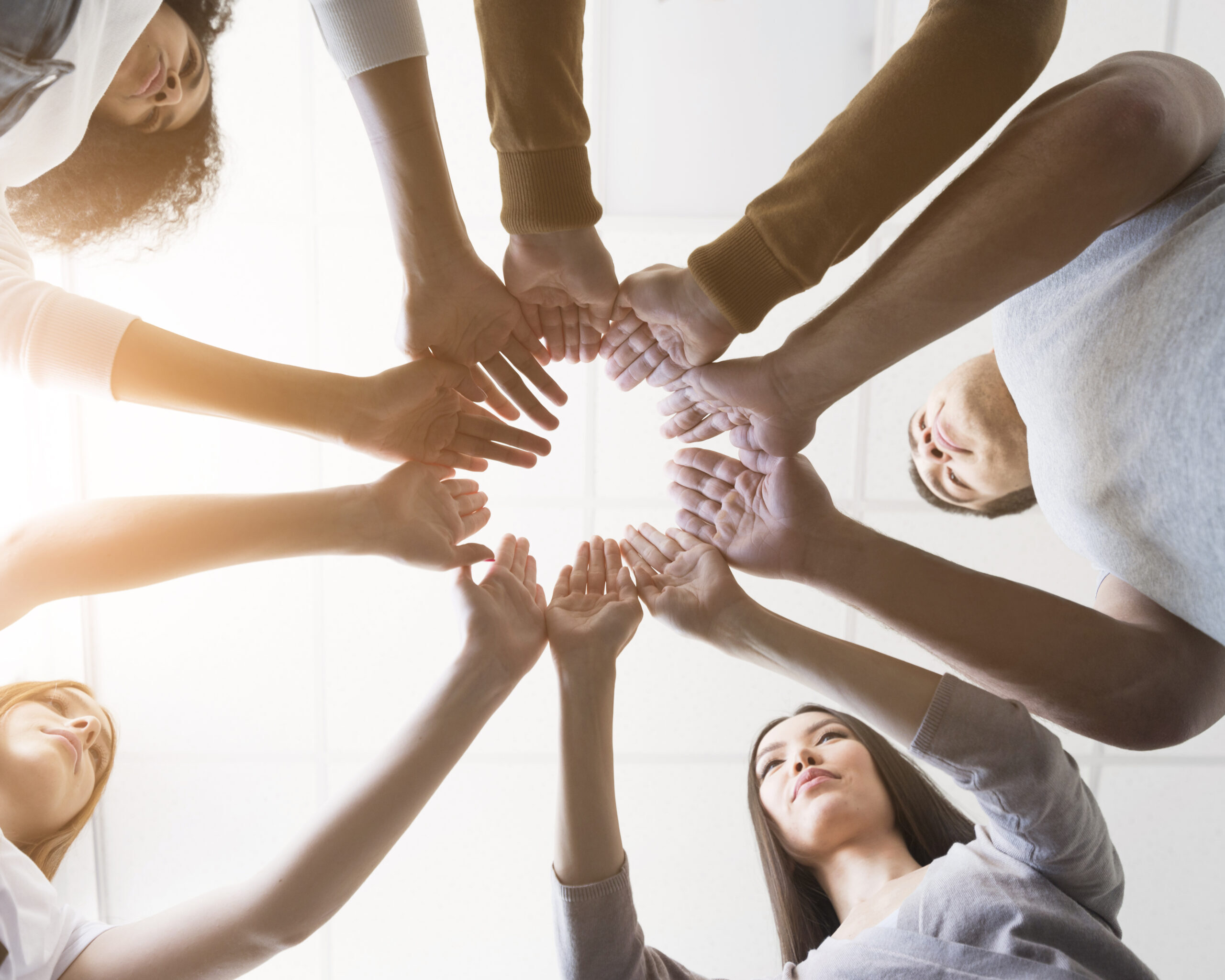 low-view-group-friends-holding-hands-together